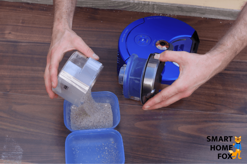 Mobiler Staubbeutel eines Saugroboters wird per Hand ausgeleert.